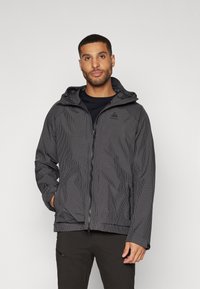 Giacca a scacchi nera e grigia con cappuccio, zip e tasche laterali. Realizzata in materiale leggero e resistente all'acqua.