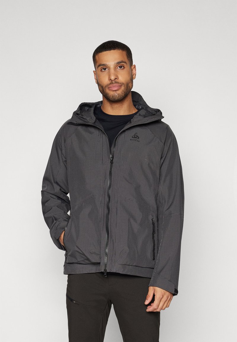 Giacca a scacchi nera e grigia con cappuccio, zip e tasche laterali. Realizzata in materiale leggero e resistente all'acqua.