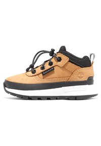 Sneaker in suede beige e nylon nero con dettagli grigi, sistema di allacciatura, suola in gomma modellata e logo Timberland sul lato.
