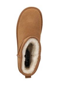 Pantufla de ante marrón con un forro blanco y mullido, forma redondeada, detalles cosidos y una lengüeta trasera para facilitar su uso. Logotipo visible en el interior.