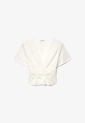 Blouse blanche à manches courtes avec col en V profond, taille élastique froncée et bas péplum légèrement évasé, présentée sur un fond blanc.