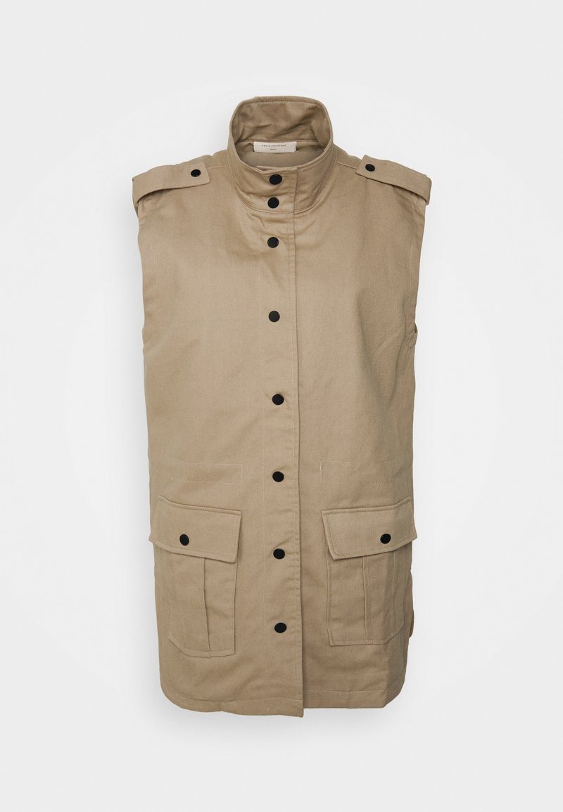 Colete sem mangas bege com gola alta, fechos de botão pretos, dois bolsos frontais com pala e epaulettes nos ombros. O tecido tem uma textura suave.