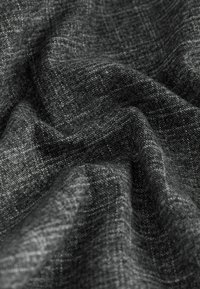 Tessuto intrecciato grigio scuro con un sottile motivo a quadretti, mostrato con pieghe naturali e una consistenza morbida.