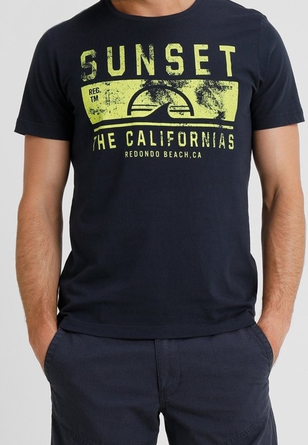 T-shirt en coton bleu marine avec un grand imprimé graphique jaune portant la mention "SUNSET THE CALIFORNIAS REDONDO BEACH, CA." Manches courtes.