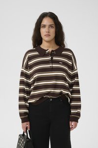 Brown and cream striped long-sleeve polo shirt with a collar, button placket, and ribbed cuffs, paired with black high-waisted pants and a handbag.