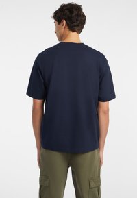 Mørkeblå bomull T-skjorte med korte ermer og rund hals, med en avslappet passform og minimalistisk design.