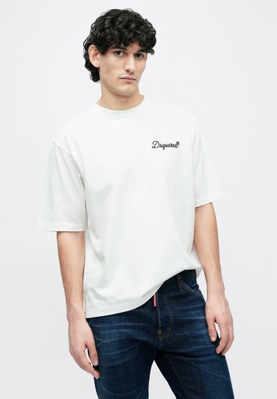 Balta īsroku kokvilnas T-krekls ar apaļu izgriezumu, kreisajā krūtīs melni izšūts "Dsquared2" logotips.