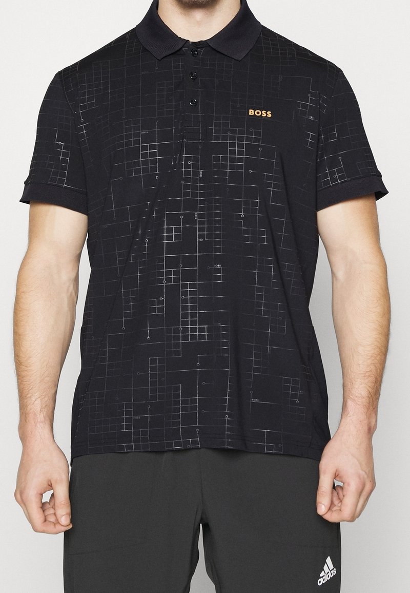 Black polo shirt featuring a geometric pattern, a structured collar, three-button placket, and "BOSS" logo in orange on the chest.