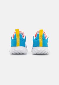 Zapatillas deportivas azules para niños con suelas blancas, lengüetas amarillas en el talón etiquetadas con "Mickey" y "Mouse", y forro interior rosa, vistas desde atrás.