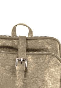 Een zachte, gestructureerde taupe leren tas met een bovenrits, een kort handvat en een zilverkleurige metalen gespaccent aan de voorkant.