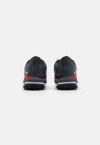 Ciemnoniebieskie buty sportowe z czerwonymi akcentami. Siatkowa cholewka z teksturowanym wykończeniem, amortyzująca podeszwa i gumowa podeszwa z wzorowanym bieżnikiem.