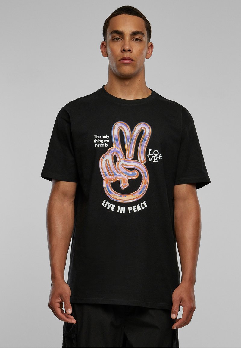 Sort bomulds t-shirt med et farverigt fredssymbol grafik og teksten "LEV I FRED" samt "Det eneste vi har brug for, er KÆRLIGHED."