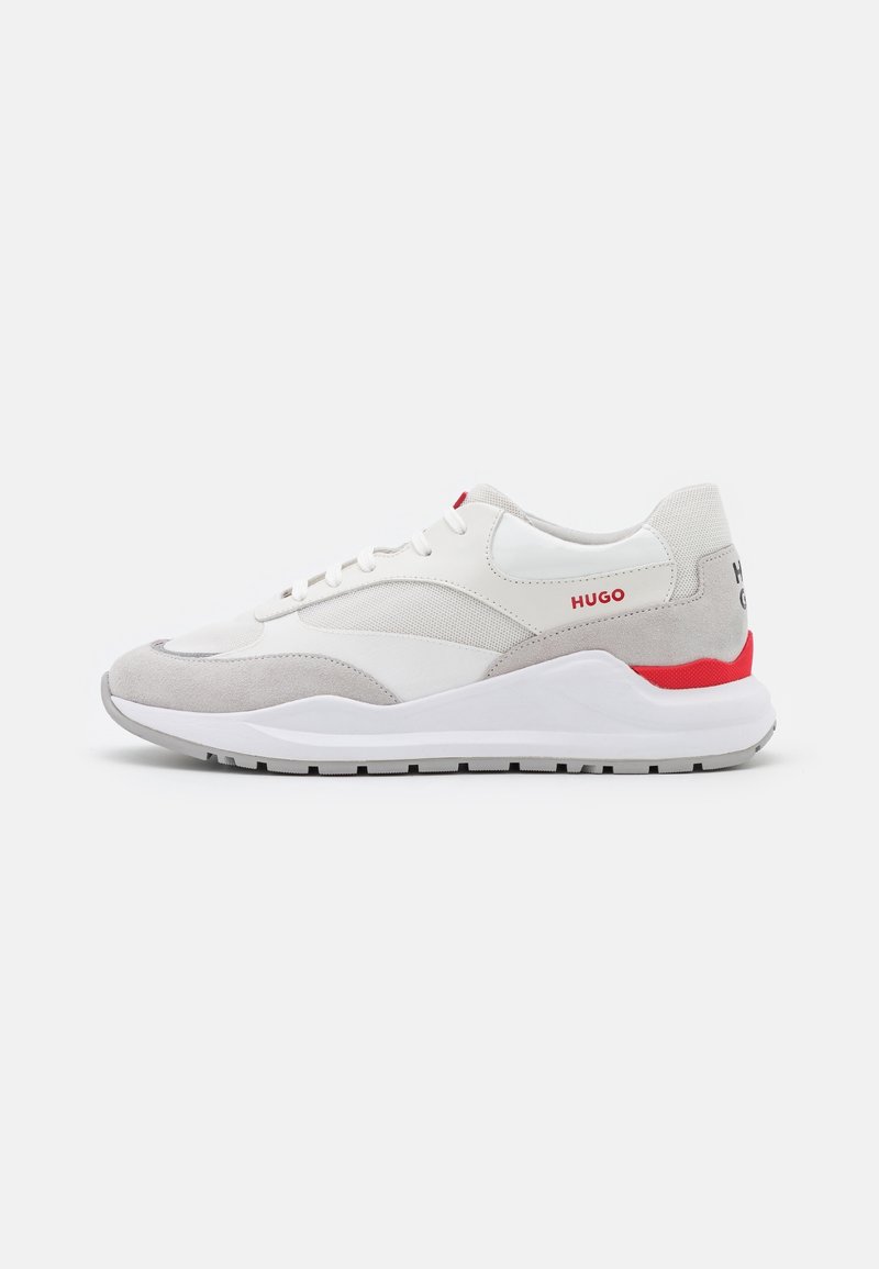 Baskets basses blanches et gris clair avec des accents rouges et un marquage "HUGO" sur le côté et le talon, présentées sur fond blanc.