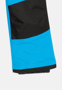 Blåa och svarta snöbyxor med en färgblocksdesign, slät textur, justerbart midjeband och elastiska muddar vid anklarna.