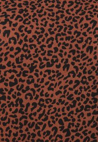 Luipaardprintstof in tinten bruin met zwarte vlekken. De textuur lijkt zacht en gestructureerd, geschikt voor kleding of bekleding.