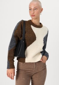 Pull en tricot avec un design coloré comprenant des sections marron, crème et gris. Texture douce avec un col rond et un ourlet côtelé.