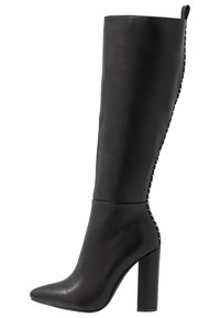 Czarne skórzane botki do kolan z ostrym noskiem, wysokim słupkowym obcasem oraz białym przeszyciem wzdłuż tylnej szwy i pętli.