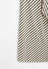 Beige tyg med svarta horisontella ränder i ett vågigt mönster. Materialet verkar slätt med en något glänsande finish.