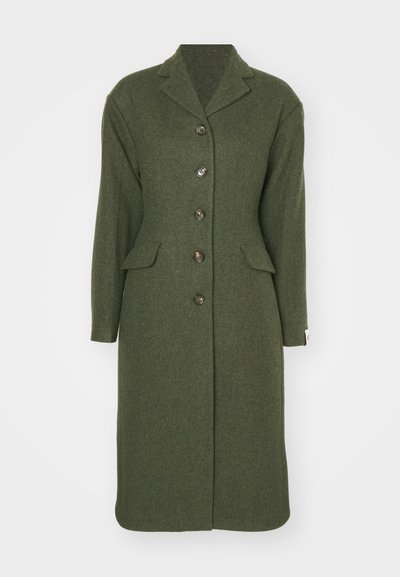 Žalias vilnonis paltas, pasižymintis ilgu dizainu, įpjautu apykakle, priekinėmis kišenėmis ir šešiais mygtukais, išdėstytais centre. Tekstūruota medžiaga.