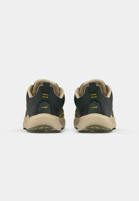 Green and black athletic shoes with a textured upper, lightweight design, padded collar, and beige midsole. Sole features traction elements.