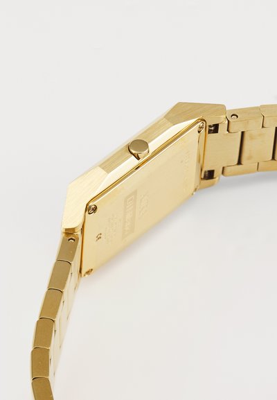 Gold-tone rectangular watch featuring a textured surface and an octagonal case. It has a metal link bracelet with a brushed finish.