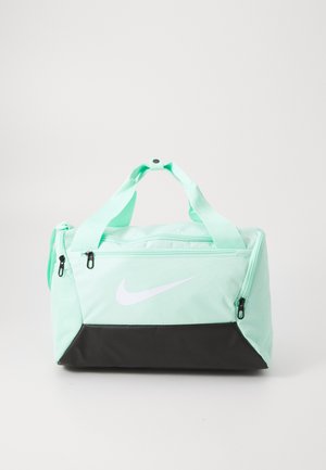 Mäta zelená športová taška s čiernym dnom, dvoma krátkymi uchami, zipsovými priehradkami a výrazným bielym logom Nike na prednej strane.