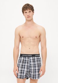 Blå og hvite rutete boxere med en svart elastisk midje som har merkets navn "JACK & JONES" tydelig vist.