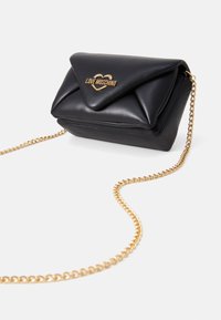 Černá kabelka z umělé kůže s zlatým řetízkem, trojúhelníkovým klopou a vyraženým logem "LOVE MOSCHINO" v designu srdce.