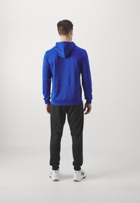adidas Sportswear SPORTSWEAR HOODED TRACKSUIT SET - Tuta - semi lucid blue/black