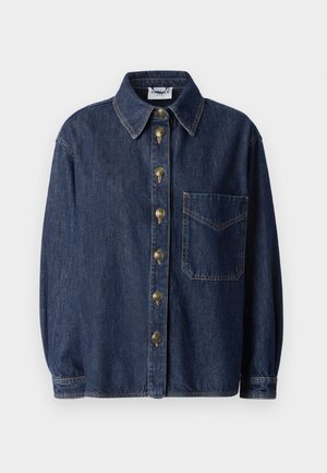 Chemise en denim bleu foncé avec une poche sur le devant, col rond et boutons métalliques. Coupe décontractée avec des manches longues et des détails de couture visibles.