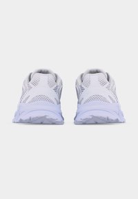 Ζευγάρι λευκών αθλητικών παπουτσιών με πλέγμα στα πλαϊνά, εμφανιζόμενα από πίσω σε απλό λευκό φόντο.