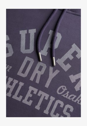 Paarse sweatshirt met grote grijze tekst "SUPER DRY ATHLETICS" en "Osaka." Voorzien van bijpassende trekkoorden met zilverkleurige metalen uiteinden.