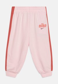 Pink sweatpants made of soft fabric, featuring a red side stripe and “Nike” logo on the left leg. Elastic waistband and cuffs.