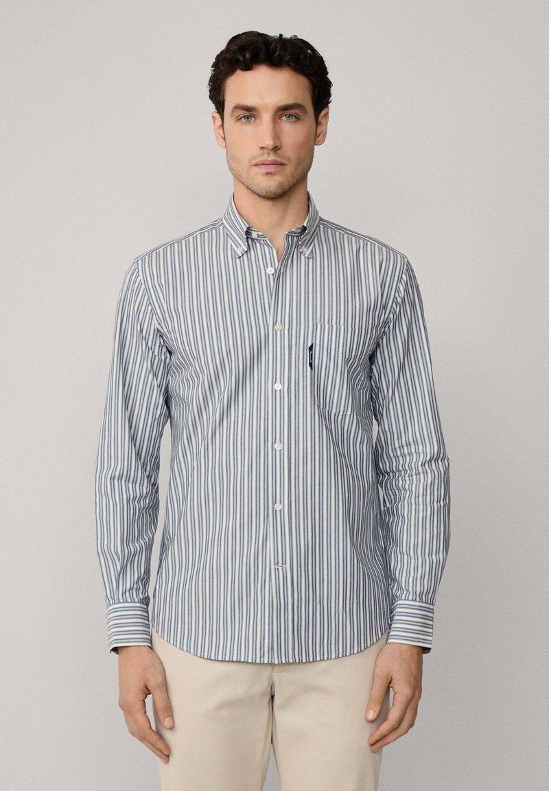 Camisa abotonada con rayas verticales azules y blancas, de mangas largas, con cuello y un bolsillo en el pecho, hecha de una tela ligera.