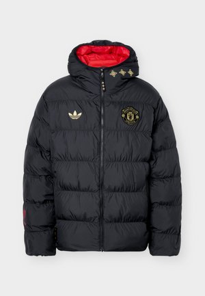 Zwarte gewatteerde Manchester United-jas met gouden logo's, rode voering, ritssluiting aan de voorkant en capuchon met decoratieve gouden elementen.