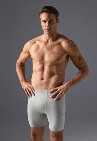 Boxer-chaussettes grises en tissu doux, avec un design ajusté et des coutures contrastantes. Pas de logos ni de graphiques visibles.