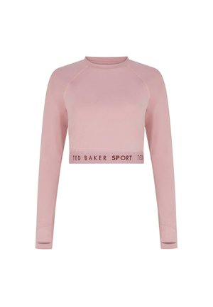 Gaiši rozā sportiska tops ar garām piedurknēm un raglanu piedurknēm. Apakšā ir dekoratīva josla ar tekstu "TED BAKER SPORT".