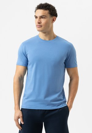 Lichtblauw, T-shirt met korte mouwen, gemaakt van zacht materiaal. Heeft een ronde halslijn en een ontspannen pasvorm, gecombineerd met donkere broek.
