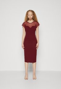 Robe de maternité bordeaux, avec des manches courtes en voile, décolleté en cœur, silhouette ajustée, longueur genoux et tissu doux.