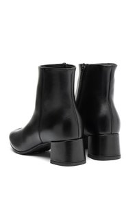 Pair of black leather ankle boots with block heels and side zippers, shown from rear angle on white background.