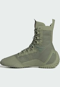 Zapatilla táctica de caña alta en verde oliva con tejido texturizado, talón reforzado, suela acolchada y cierre frontal con cordones.