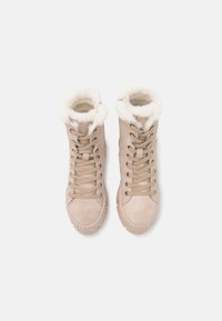 Stivaletti alla caviglia in suede beige con foderatura in pelliccia sintetica, punta rotonda e suola in gomma spessa. Presenta lacci e zip laterale per una facile calzata.