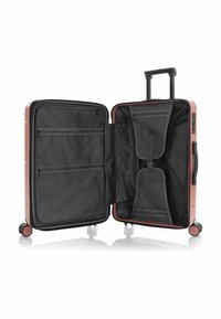Hard-shell suitcase in rose color with a black lining. Interior features mesh pockets and straps for organization. Four wheels for mobility.