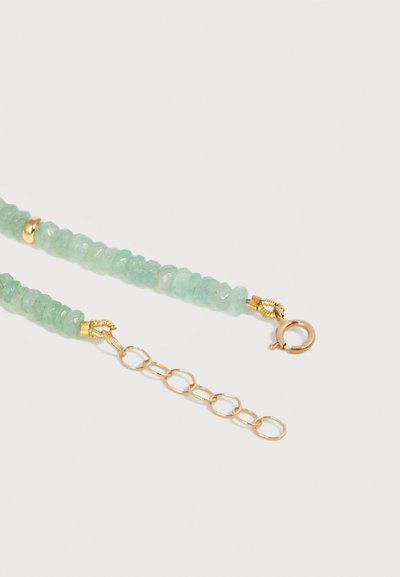 Πράσινο περιδέραιο με πολύγωνες χάντρες, χρυσή αλυσίδα επέκτασης και κούμπωμα με ελατήριο σε λευκό φόντο.