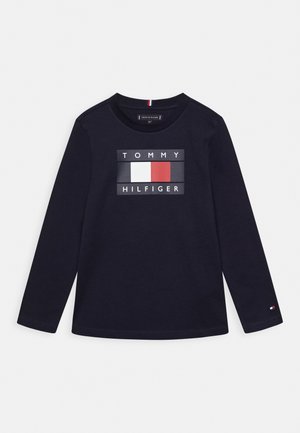Langsleeve marineblauwe T-shirt gemaakt van katoen met een rechthoekige grafische print met "TOMMY HILFIGER" en logo-accenten in wit, rood en blauw.