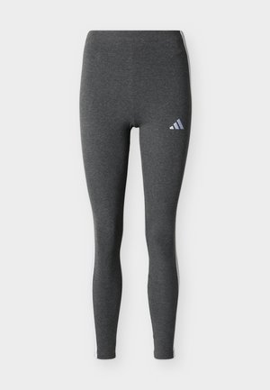 Leggings de sport gris foncé avec des bandes blanches sur les côtés et un petit logo Adidas blanc sur la partie supérieure de la cuisse gauche.