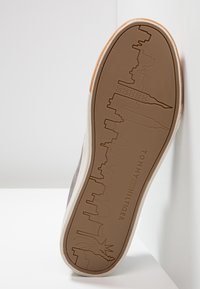 Podešev boty s vyrytým panoramatem New Yorku, včetně Sochy svobody a budovy Empire State, s brandingem "Tommy Hilfiger".