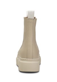 Botín de cuero beige con superficie texturizada, paneles laterales elásticos y suela de goma gruesa. Cuenta con una lengüeta en la parte posterior.