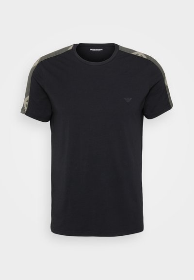 T-shirt nera in cotone con maniche corte. Presenta dettagli a motivo camouflage sulle spalle e un piccolo logo sul petto.