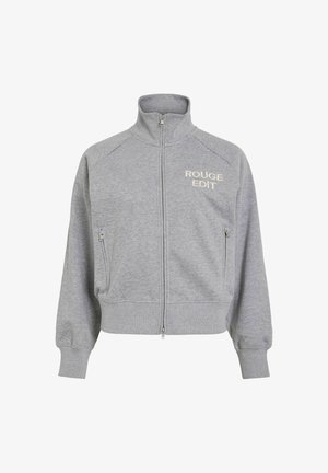 Grijze ritssluiting jas met hoge kraag, twee zijzakken en "ROUGE EDIT" lichtkleurig geborduurd op de borst. Zacht materiaal en ontspannen pasvorm.